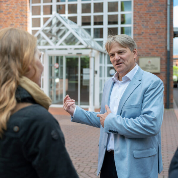 Bürgermeister Oliver Theiß vor der Stadtverwaltung von Stadthagen im Gespräch mit Bürgerinnen.